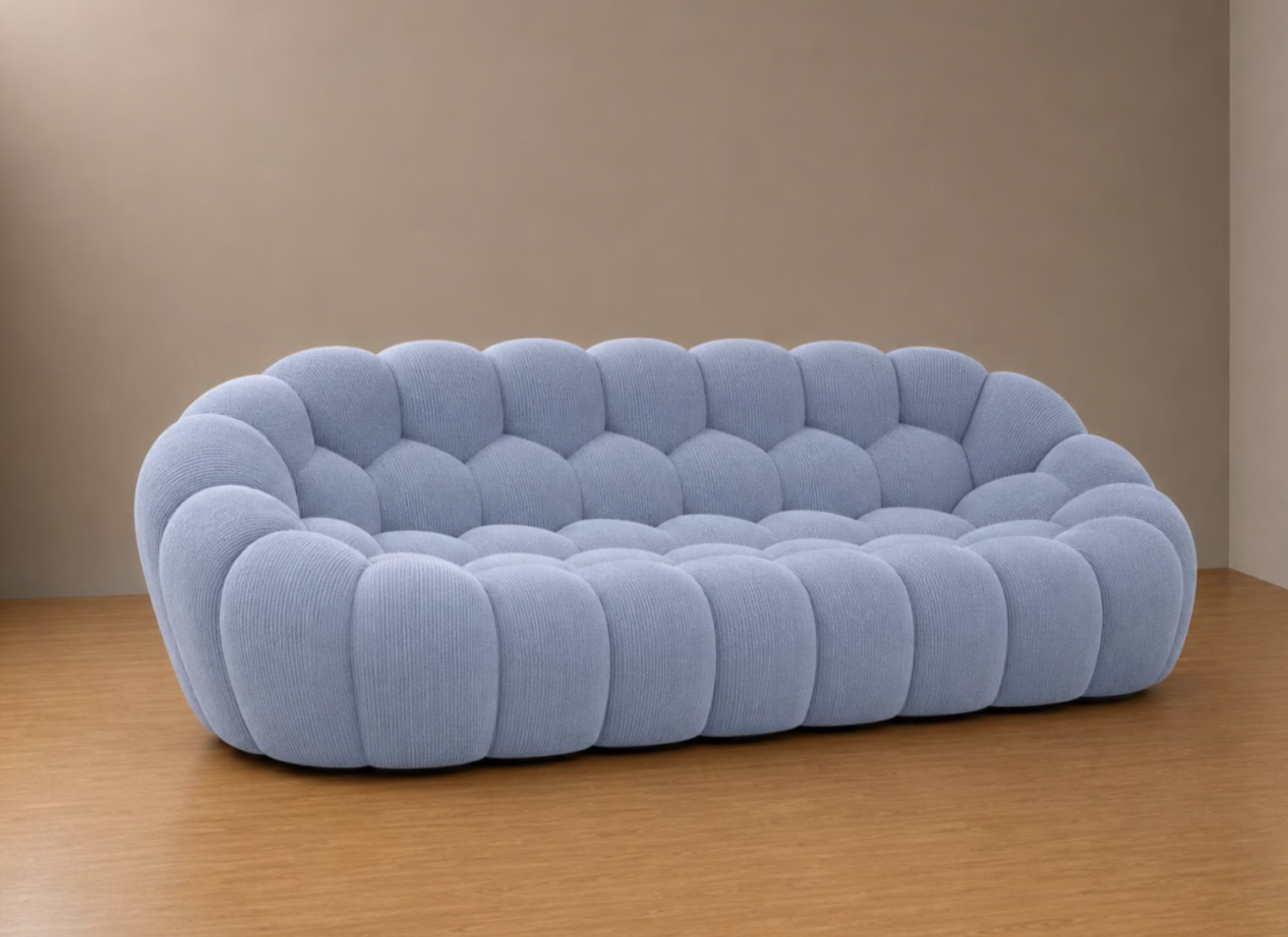Sofá Bubble icónico tapizado con relieve globular en tono azul celeste sobre suelo de madera
